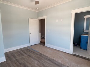 Ein Zimmer mit hellblauen Wänden, Holzboden und einer weißen Tür.