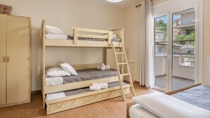 Habitación con literas, un armario y un balcón con vistas.
