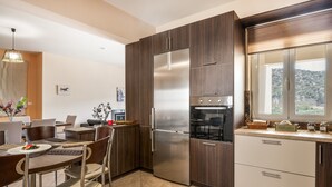 Una cocina moderna con armarios de madera oscura, electrodomésticos de acero inoxidable y una zona de comedor con mesa y sillas.
