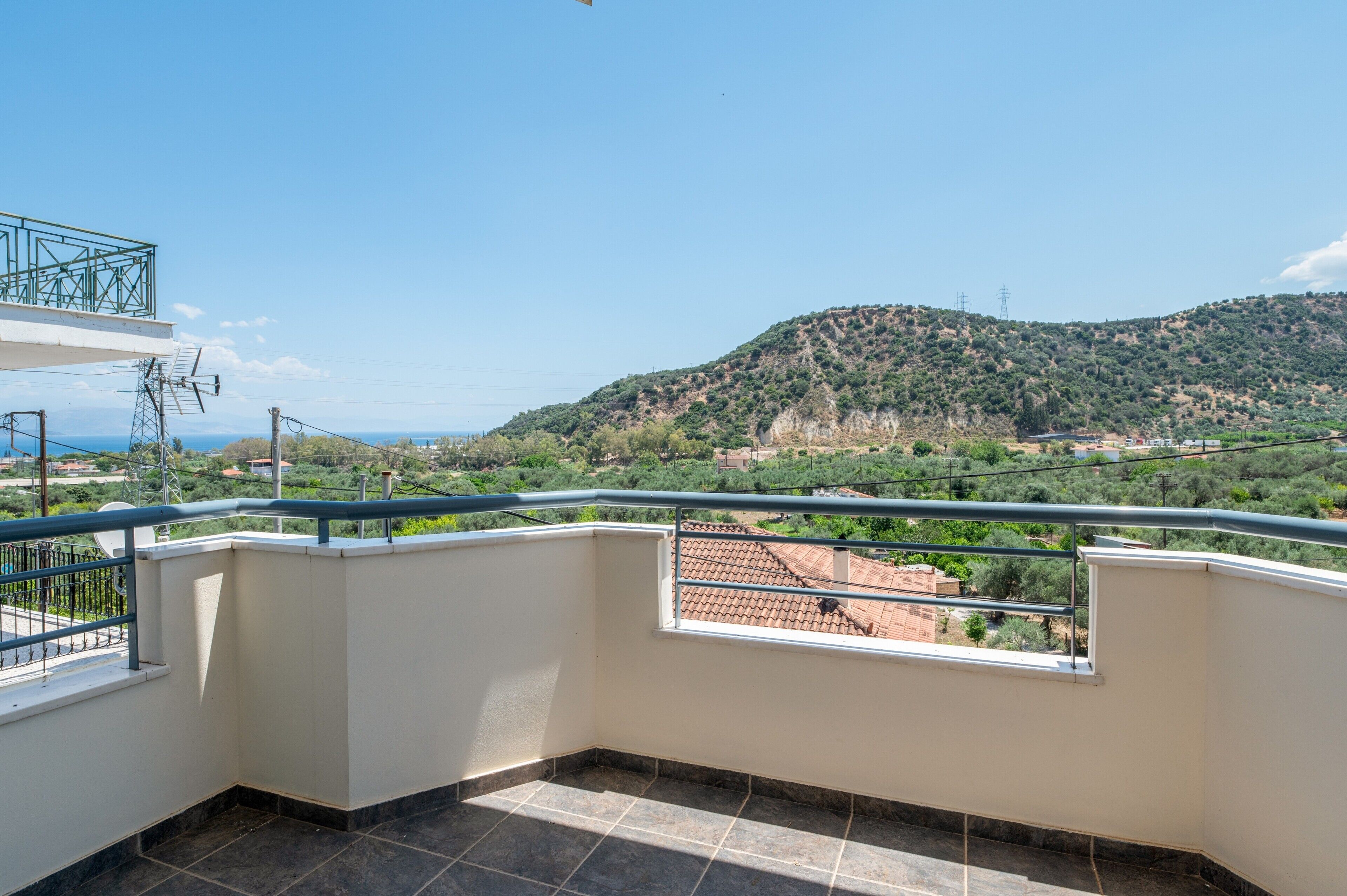 Un balcón con vista a un paisaje montañoso y edificios distantes.