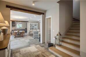Ein modernes Interieur mit Treppe, Essbereich und Küche.