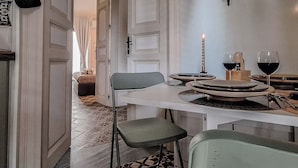 A dining area with a table set for two, a candle, and a wine glass. - Suite Home Vincenzo Bellini (Caltanissetta)