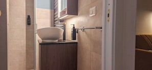 A modern bathroom with a large white basin, a towel rack, and a bottle of hand soap. - Suite Home Vincenzo Bellini (Caltanissetta)