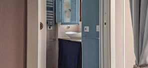 A bathroom with a sink, mirror, and towel rack. - Suite Home Vincenzo Bellini (Caltanissetta)