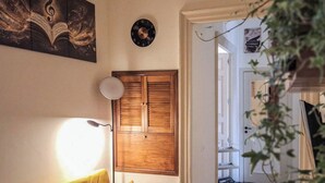 A room with a wooden wardrobe, a clock, and a framed picture on the wall. - Suite Home Vincenzo Bellini (Caltanissetta)