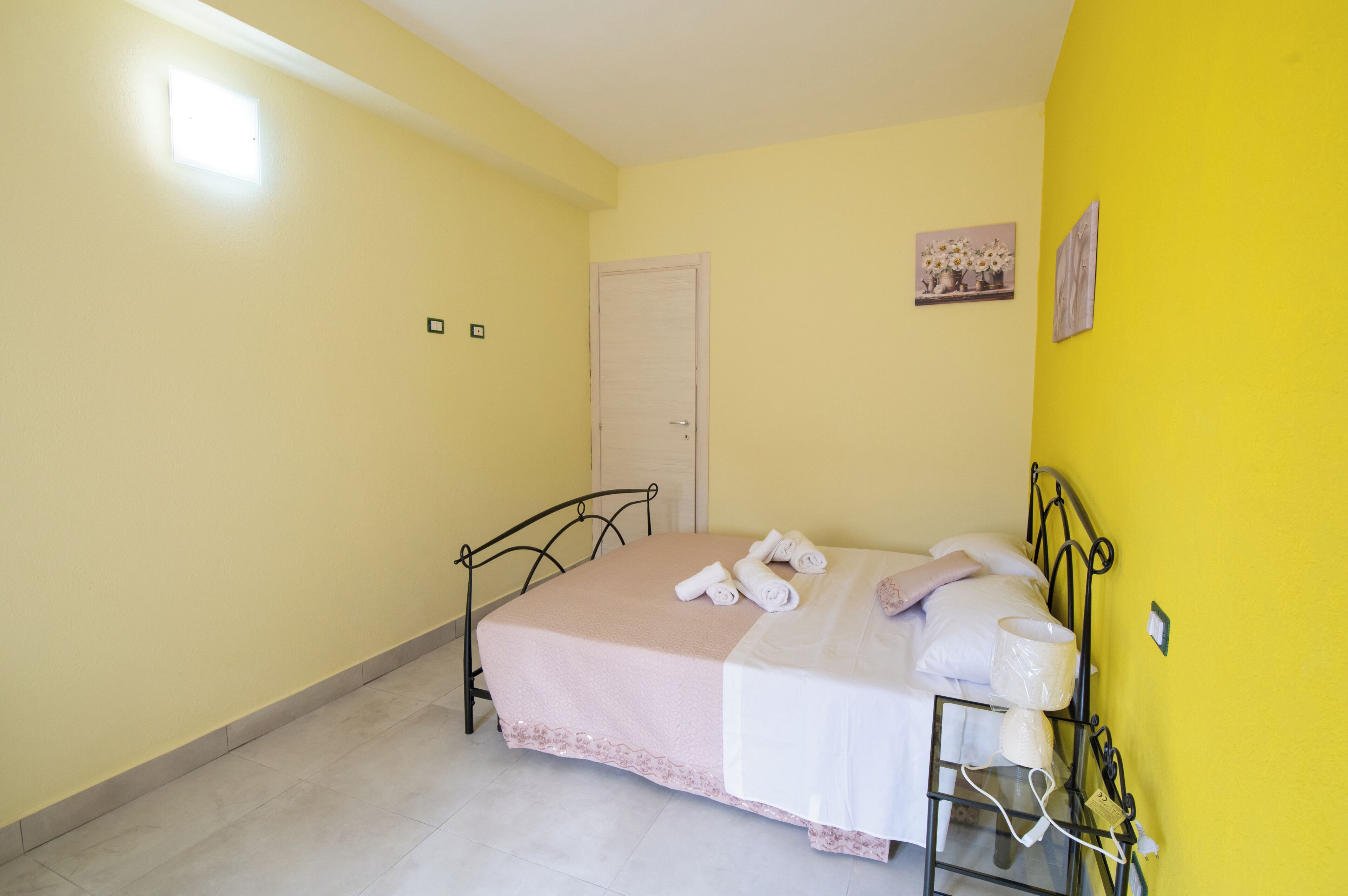 Ein Schlafzimmer mit Bett, Tür und einer Wandleuchte.