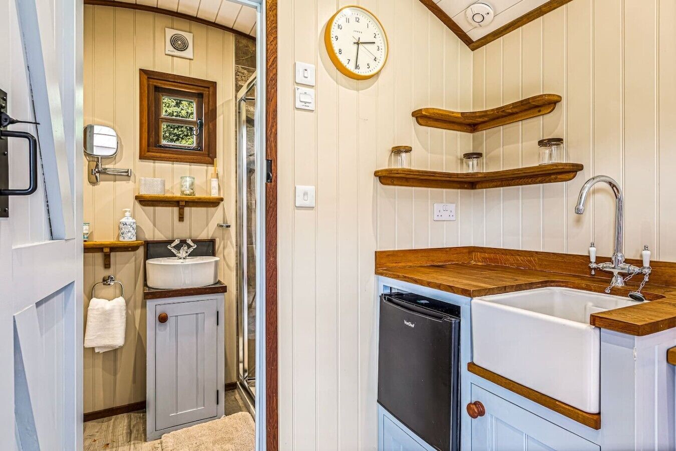 A compact kitchen with a sink, wooden countertop, and a dishwasher.