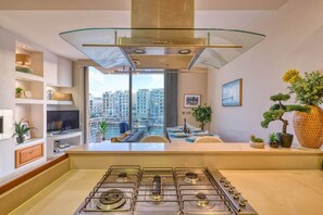 Eine moderne Küche mit Gasherd, einer Glasdecke und Blick auf hohe Gebäude.