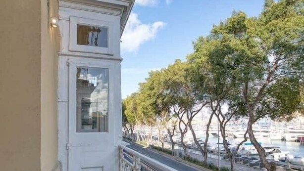 Ein Balkon mit Tisch, Stühlen und Blick auf den Hafen.