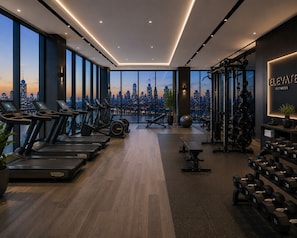A modern gym with treadmills, weights, and a city view. - Lucentia Residence by Bukit Bintang (Kuala Lumpur)