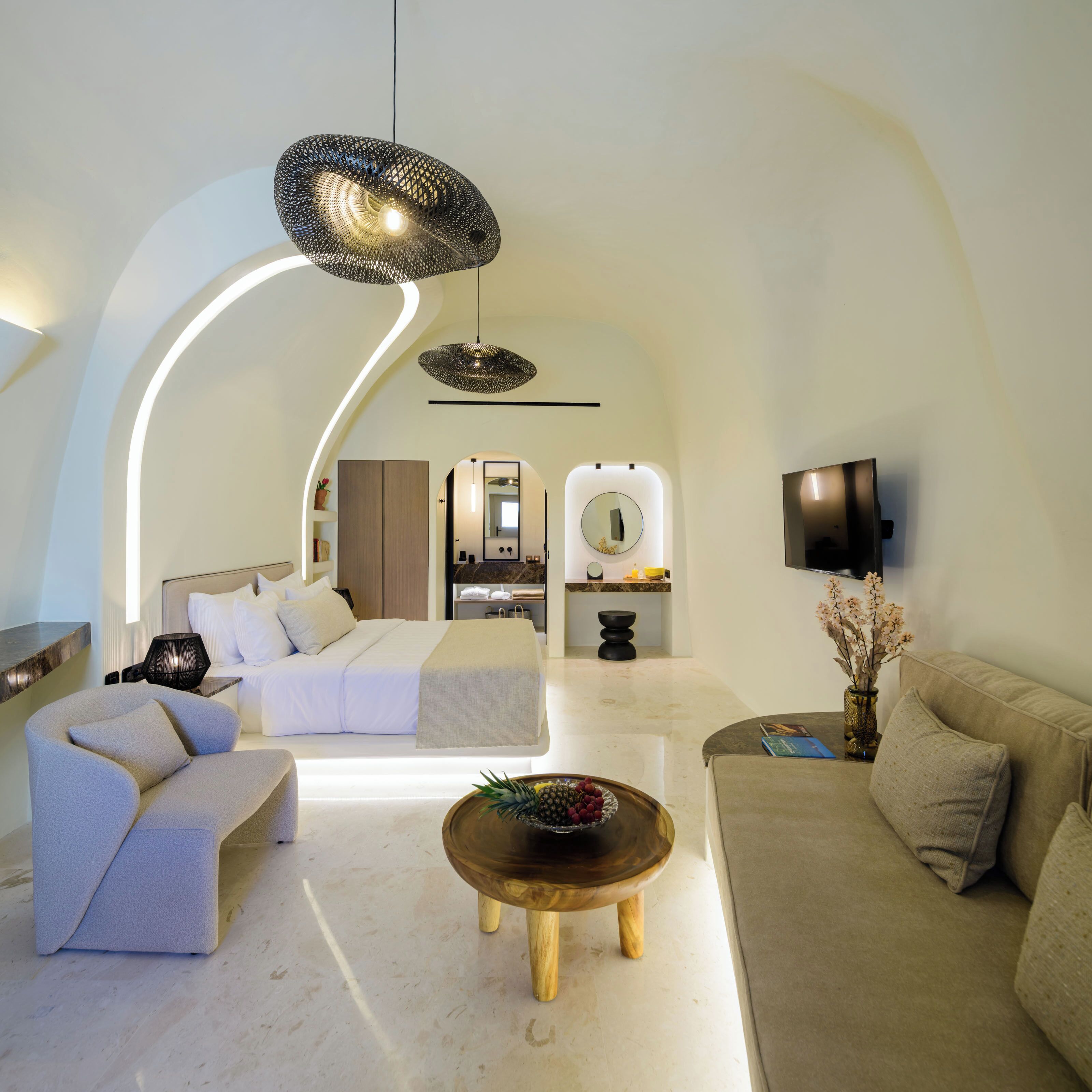 A modern living room with a curved ceiling, a sofa, a coffee table, and a TV.