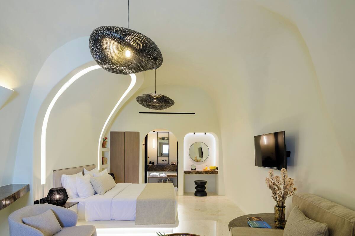 Un salon moderne doté d’un plafond incurvé, d’un canapé, d’une table basse et d’un téléviseur.