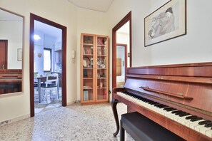 A piano in a hallway with a dining area in the background. - GuestHost - Giuliana & Antonio in Montedonzelli (Napoli)