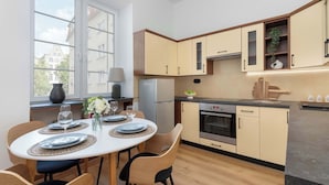 Una cocina moderna con zona de comedor, que cuenta con un amplio ventanal, armarios empotrados y una isla central.