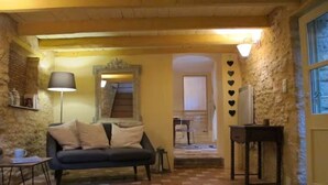 Een gezellige kamer met een bank, een lamp, een klein tafeltje en een decoratieve spiegel.