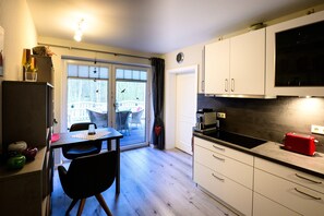 Una cocina con comedor, vistas al exterior y un reloj en la pared.