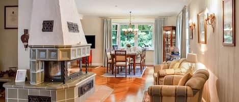 Una sala de estar con chimenea, comedor y un conjunto de sofás.
