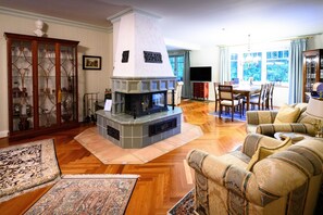 Una sala de estar con chimenea, muebles de madera y un ventanal grande.