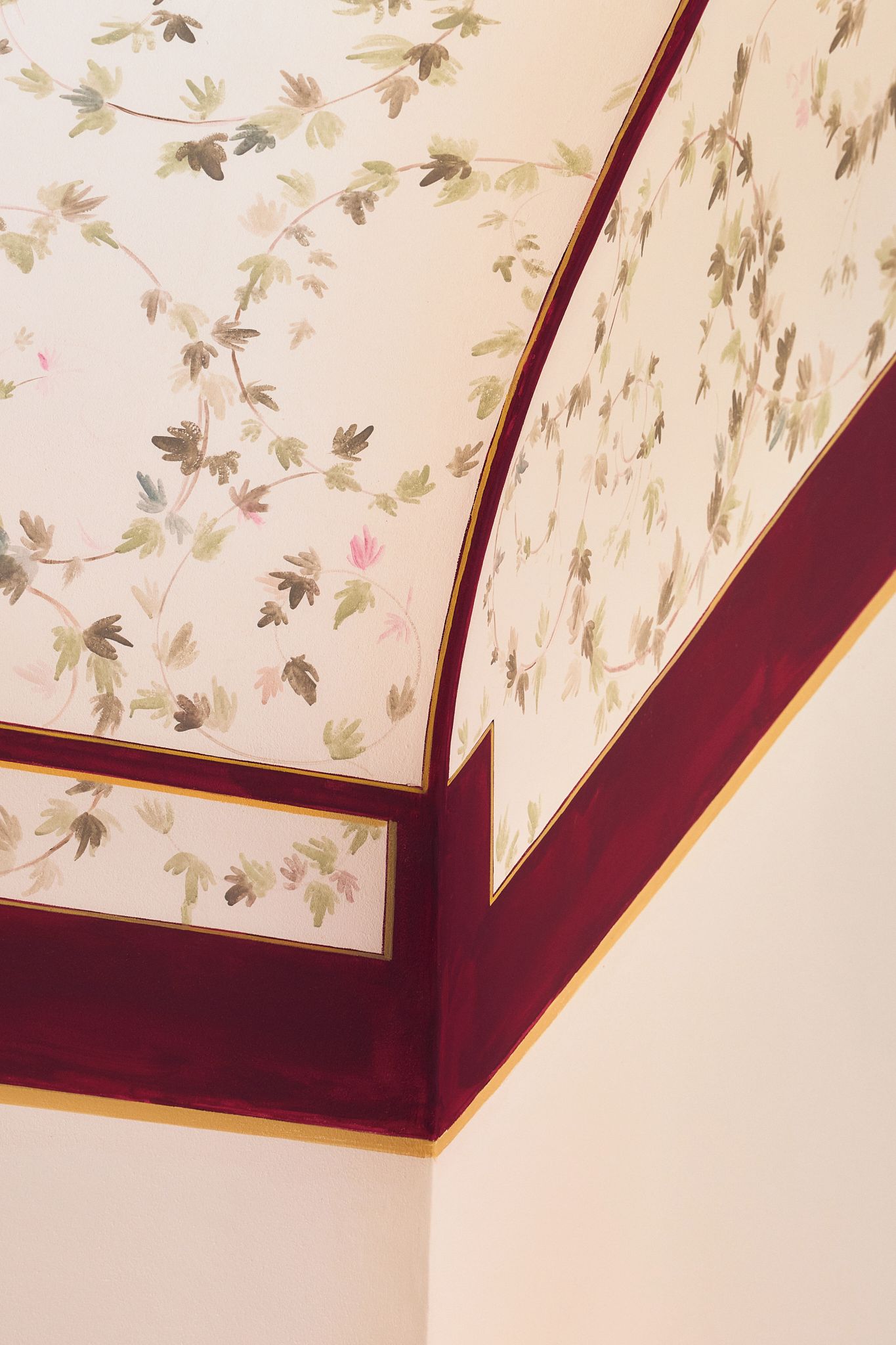 Un techo con papel tapiz floral y molduras de madera oscura.