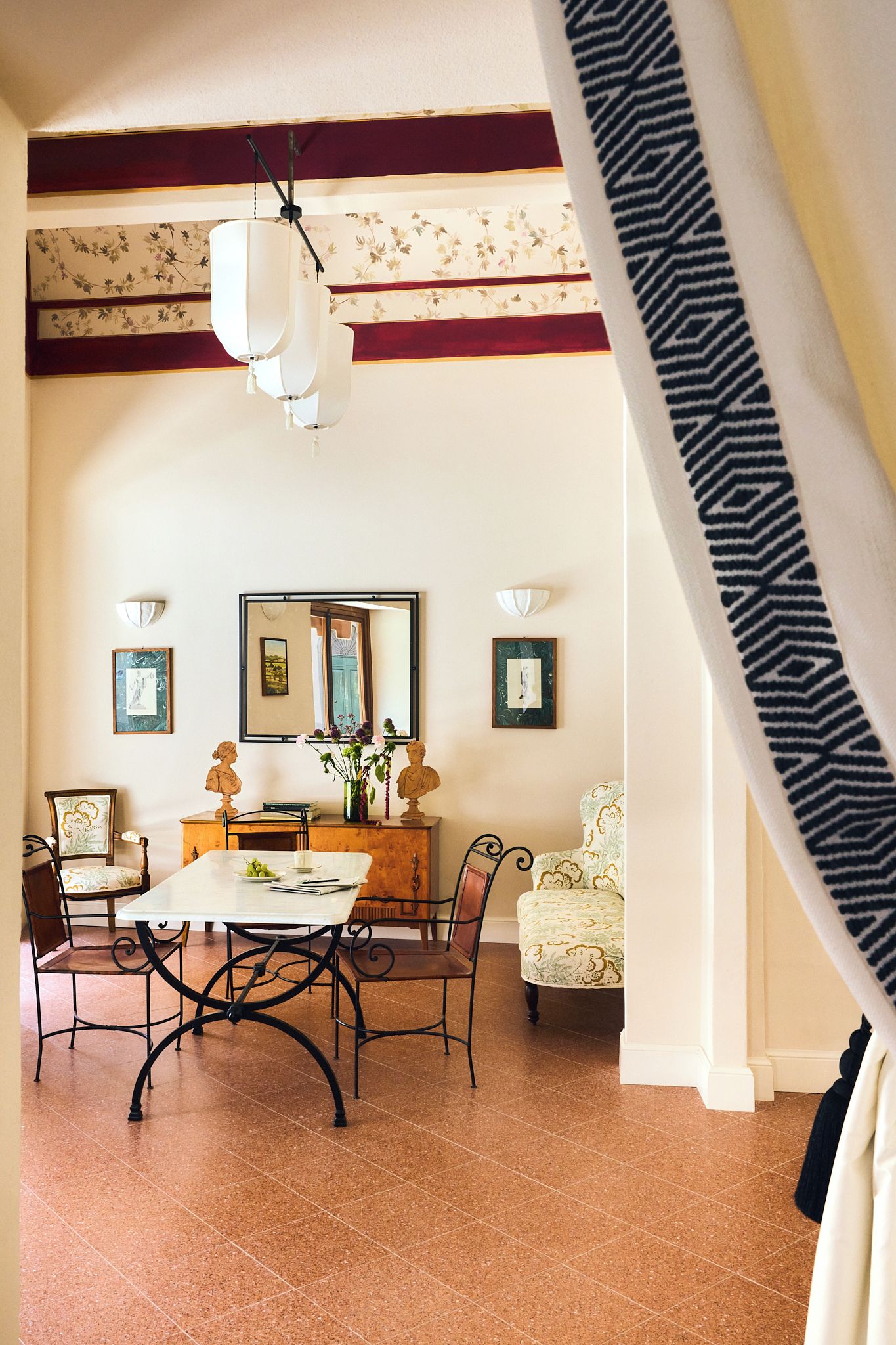 A dining area with a table, chairs, and a decorative mirror.