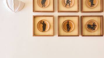 Un mur orné de neuf silhouettes encadrées représentant des personnages historiques et des animaux, disposées selon une grille de 3 sur 3.