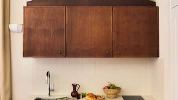 A kitchen with wooden cabinets, a sink, a countertop, and a chair.