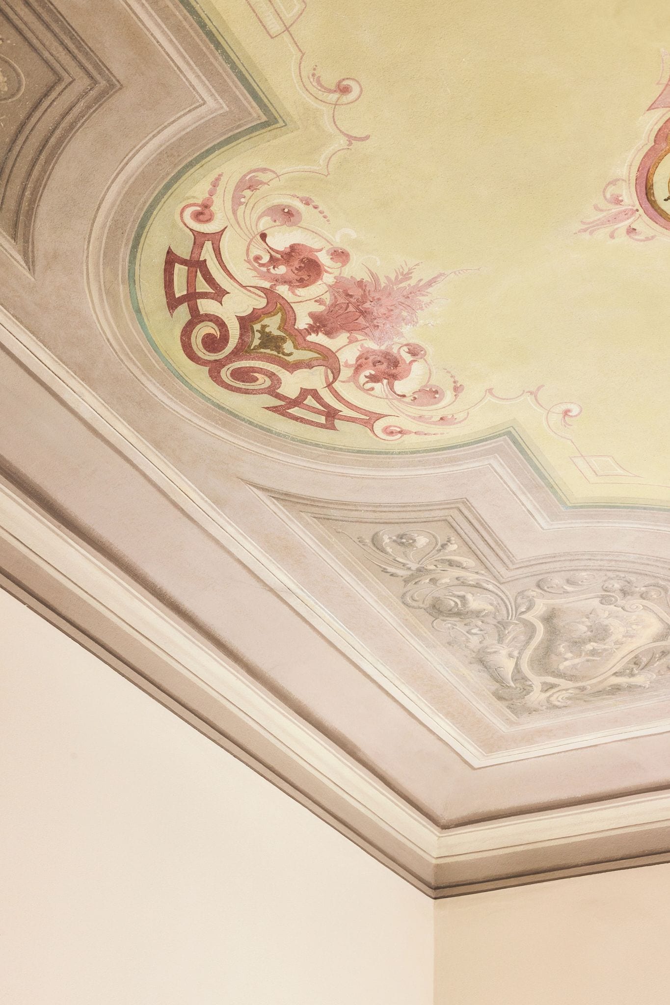 A ceiling with ornate floral and geometric patterns.