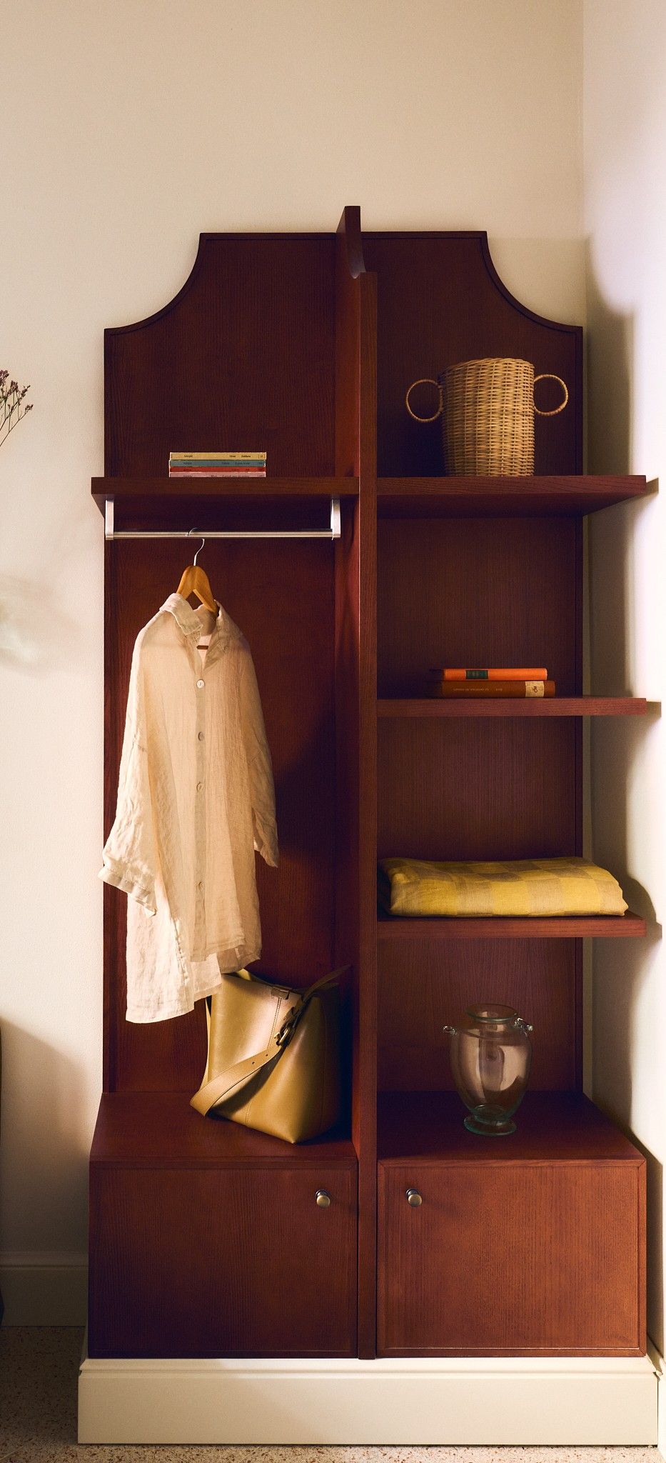 Ein Holzschrank mit Kleiderhaken, Regalen und einem Unterschrank.