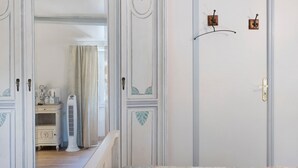 A room with a white door, a small cabinet with a radiator, and a curtain.