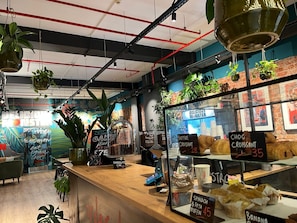 Un comptoir de boulangerie où sont exposés divers produits de boulangerie, ainsi qu’une affiche annonçant un gâteau spécial.