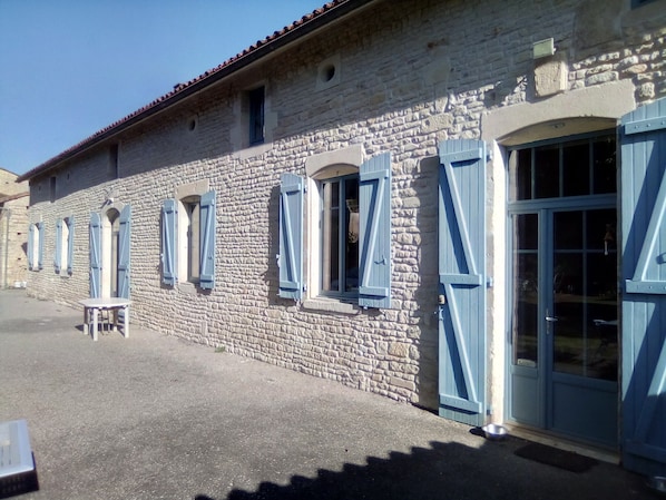 A stone building with multiple windows and a door.