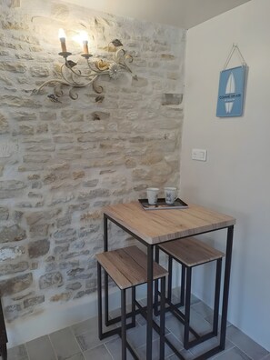A rustic stone wall, a table with a tray, and a wall-mounted sign. - Holiday Home 'Gite Des Amoureux' with Shared Pool, Shared Terrace and Wi-Fi (Longré)