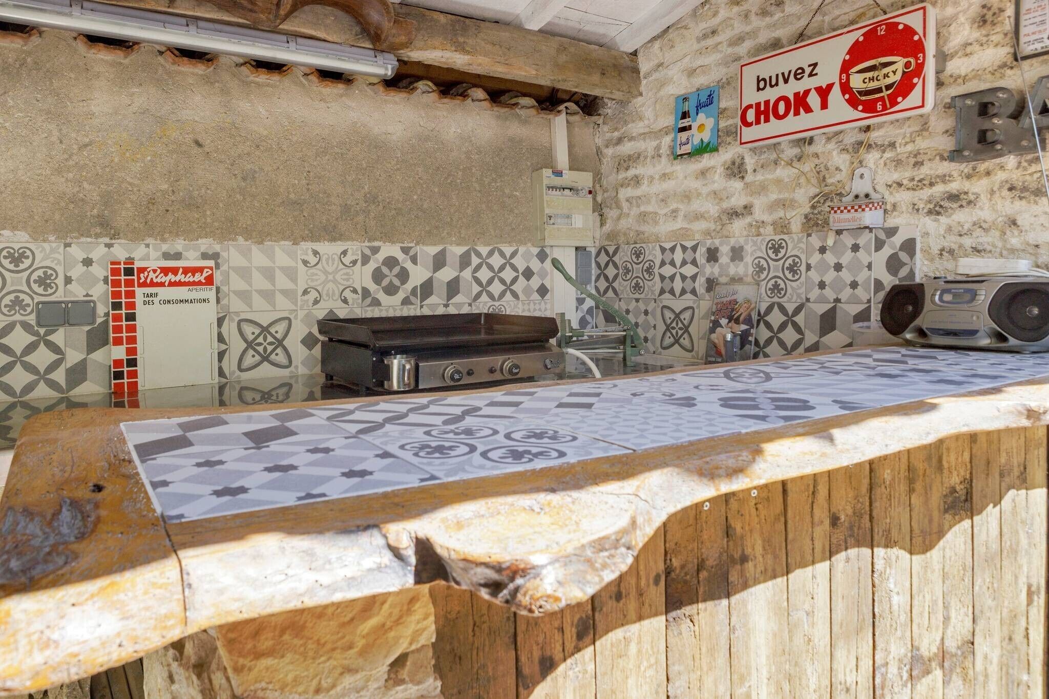 A kitchen area with a tiled backsplash, a gas stove, and a coffee machine.