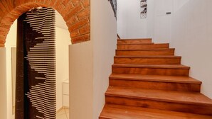 Una scala con gradini in legno e un arco in mattoni.