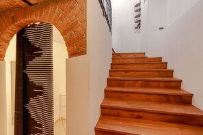 Una scala con gradini in legno e un arco in mattoni.
