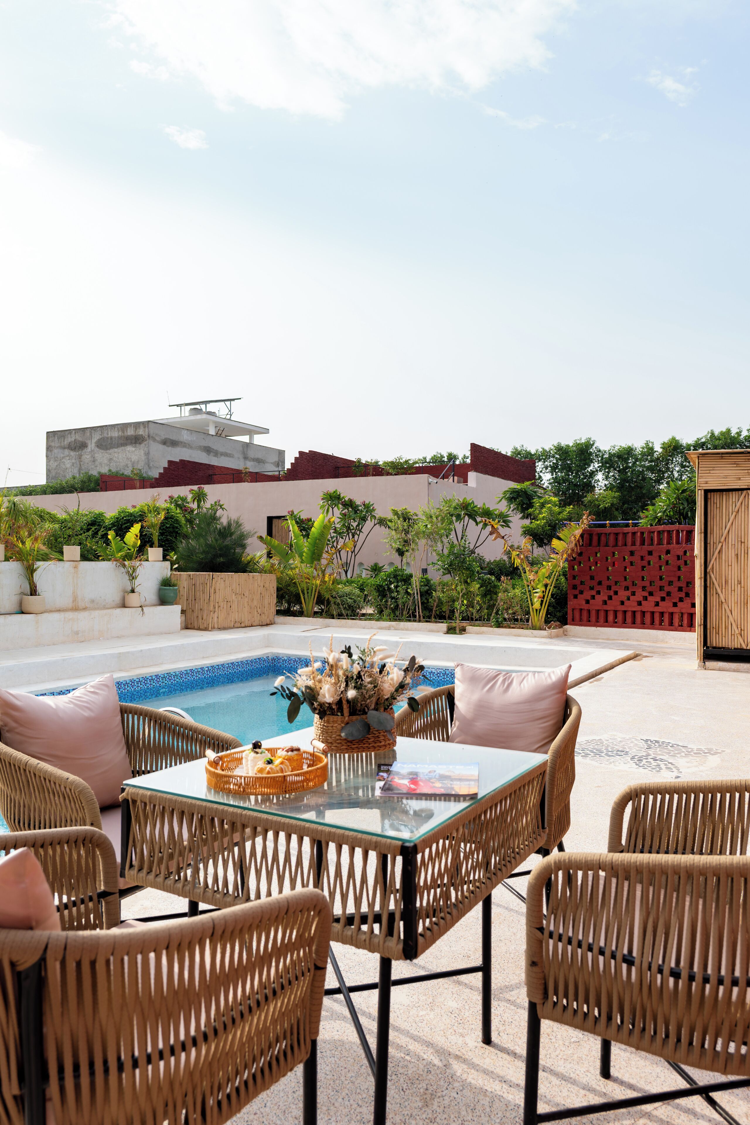 Terraza en la azotea con piscina, mobiliario de mimbre y cerca de madera.