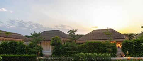 A thatched-roof building with a well-maintained garden in front.