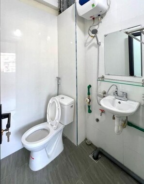 Un baño moderno con inodoro, lavabo y ducha.