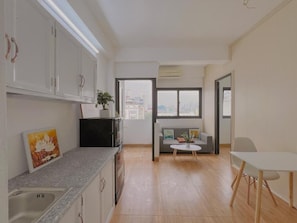 Een moderne keuken met witte kastjes, een granieten aanrecht, een spoelbak en een raam met uitzicht op de stad.