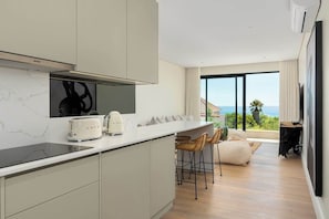 Eine moderne Küche mit einer großen Kochinsel, einem Toaster und Meerblick.