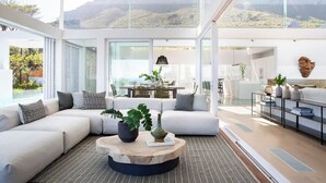 Ein modernes Wohnzimmer mit einer Eckcouch, einem runden Couchtisch und Blick ins Freie.