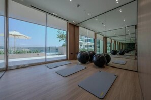 Ein modernes Fitnessstudio mit großen Fenstern, Trainingsmatten und großen Trainingsbällen.