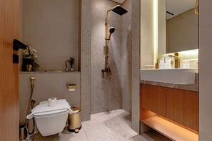 Een moderne badkamer met douche, toilet en wastafel.