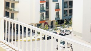 Un edificio de varios pisos con balcones, un letrero que dice 'VIDA', y vista a la calle con coches estacionados.