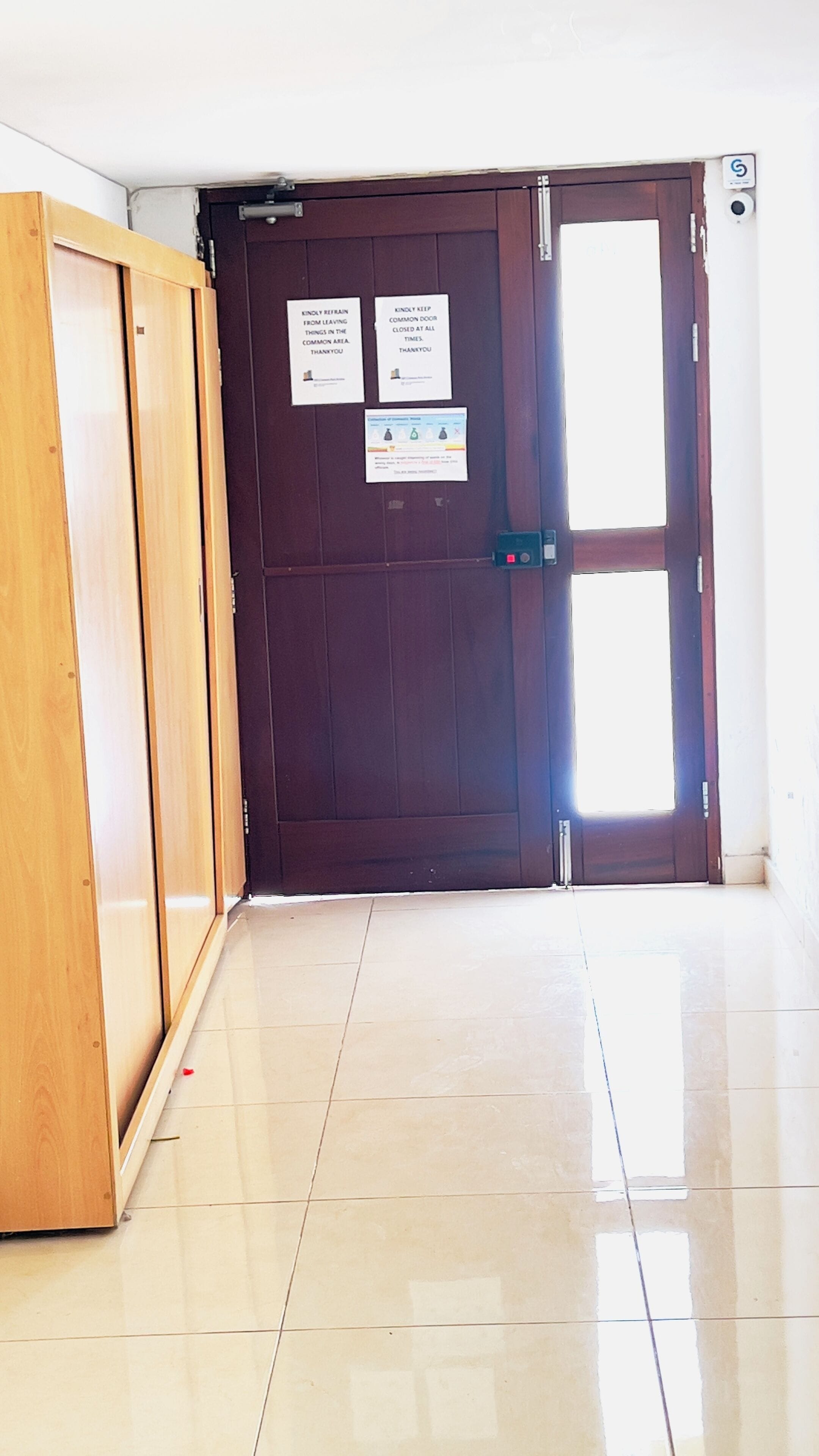 A closed wooden door with a sign requesting to keep the door closed at all times.