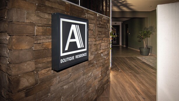 A sign on a brick wall reading 'BOUTIQUE RESIDENCE.' - Alexandra Residence Seaside (ALEXANDROUPOLIS)
