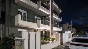 A multi-story building with balconies, a sign for 'ALEXANDRA BOUTIQUE RESIDENCE,' and a parked car. - Alexandra Residence Seaside (ALEXANDROUPOLIS)