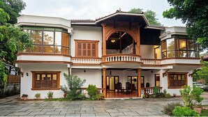 A two-story house with a balcony, large windows, and a stone-paved entrance. - Samudra Heritage (Kochi)