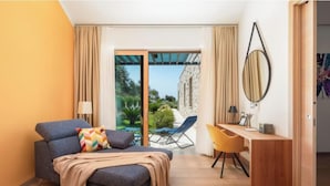 Een moderne hotelkamer met een slaapbank, een bureau, een stoel, een grote spiegel en een schuifdeur naar een buitenruimte.