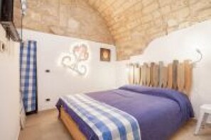 Ein Schlafzimmer mit Bett, Schminktisch, Spiegel und Fenster.